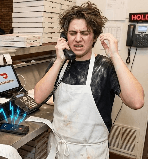 Chaotic pizzeria scene with multiple tablets and phones ringing